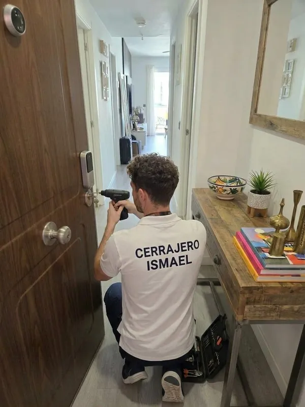 Ismael Granada, cerrajero en Granada, instalando una cerradura electrónica en la puerta de una vivienda
